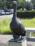 907347 Afbeelding van een bronzen beeldje van een gans met kuikens, op het terrein bij de ingang van het Strandbad ...